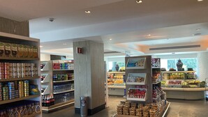 L’intérieur d’une épicerie, avec des étagères remplies de conserves, de boissons et d’aliments emballés.
