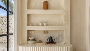 A kitchen with a white countertop, a coffee maker, and a vase on the shelf. - Bohemian 2BR Private Suites By Orivista (Kerobokan)