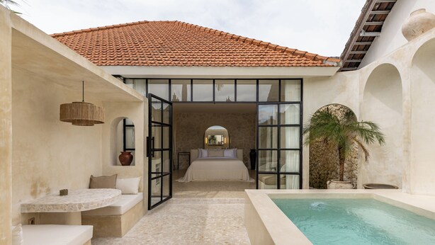 A spa area with a pool, seating, and a bedroom with a view. - Bohemian 2BR Private Suites By Orivista (Kerobokan)