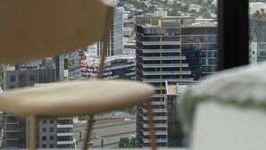 Vista panorámica de la ciudad desde un edificio alto, con una silla en primer plano.