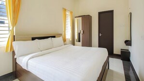 A hotel room with a large bed, a wardrobe, a door, and a mirror. - Shree Mantra Residency  (Yercaud)