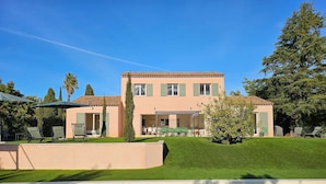 Una casa a due piani con una piscina in primo piano.