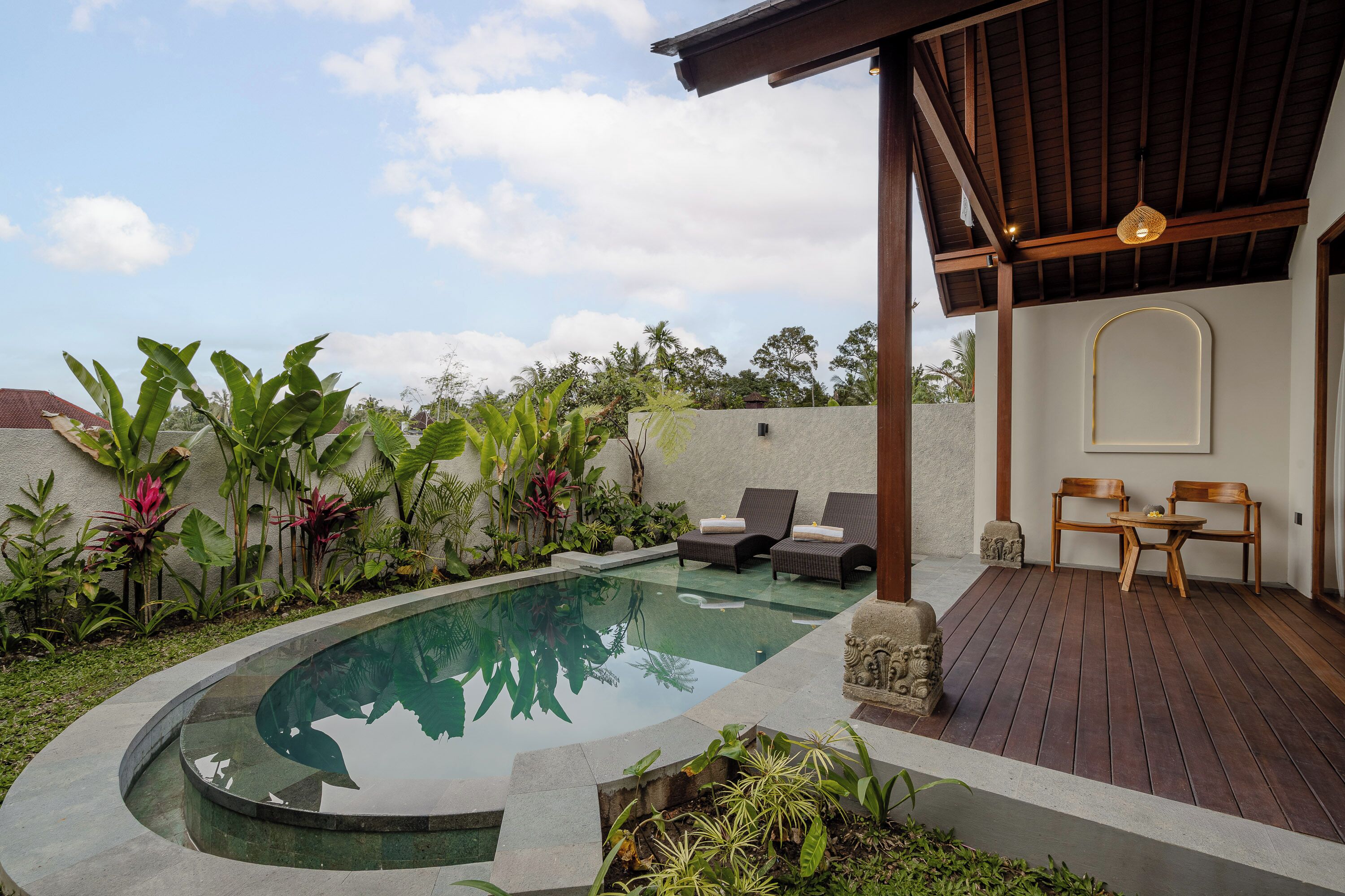 Uma área de piscina privativa com espreguiçadeiras e deck de madeira.