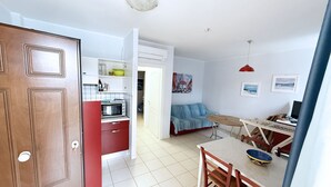 Un espacio habitable compacto con kitchenette, comedor y sofá.
