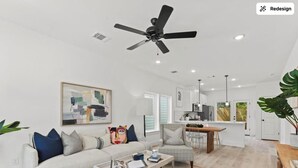 A modern living room with a sofa, coffee table, and a ceiling fan. - Spacious Modern Home w/ Smart Entry (Houston)