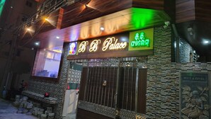 A building with a neon sign reading "BB Palace" and a welcome sign with a statue. - Collection O Sea Beach Puri (Brahmagiri)