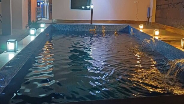A pool area with water features and lighting. - PHS KASAULI HILLS (Krishangarh)