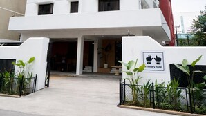 A multi-story hotel with a white facade, multiple windows, and a sign indicating it is a hotel. - The 5 Story (Hyderabad)