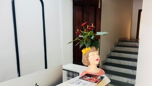 A reception desk with a mannequin head, a potted plant, and a magazine. - The 5 Story (Hyderabad)