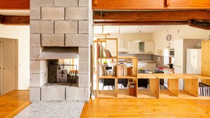 A modern kitchen with wooden cabinets, a built-in stove, and a dining area with a wooden table and chairs.