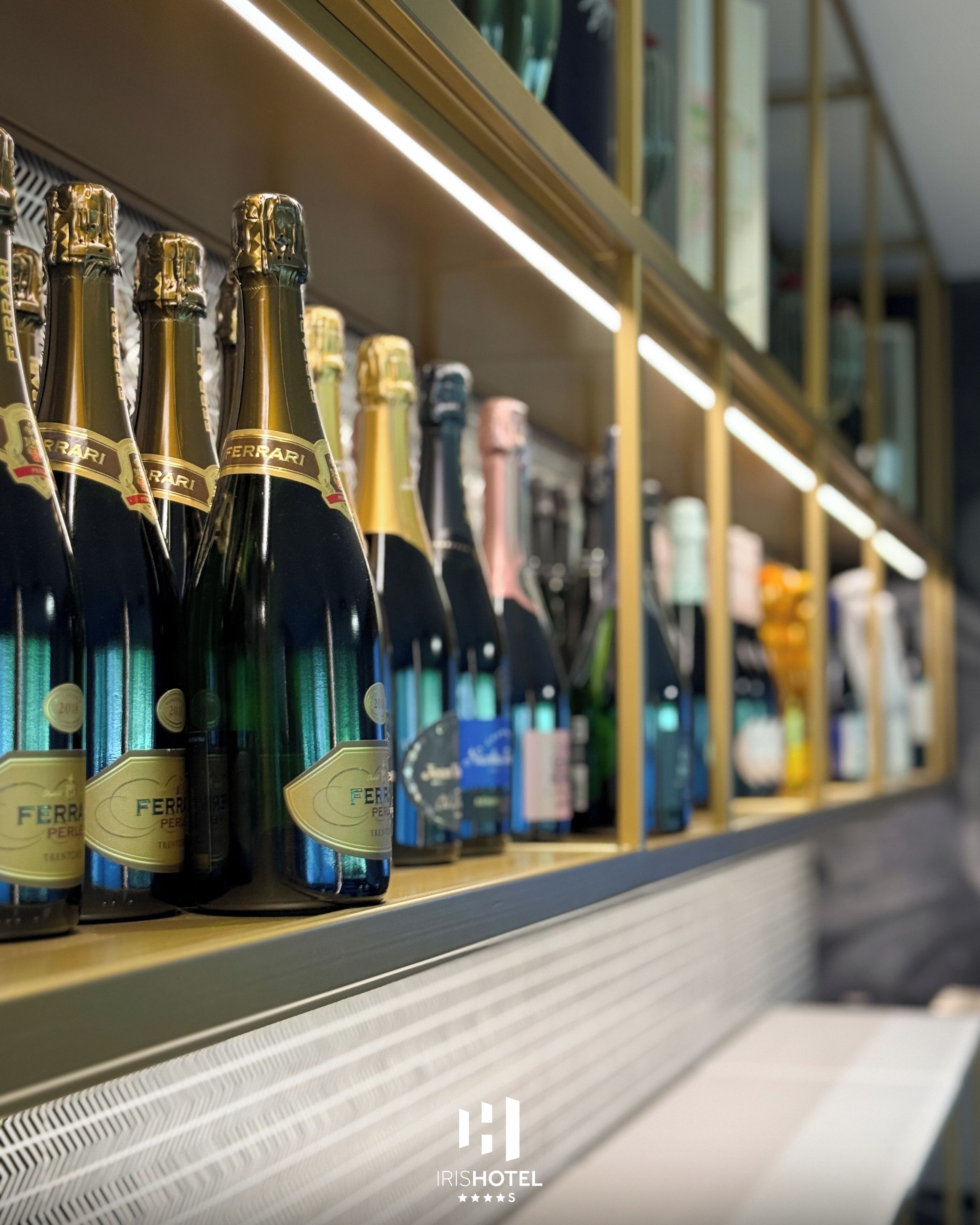 A row of champagne bottles on a shelf in a hotel setting.