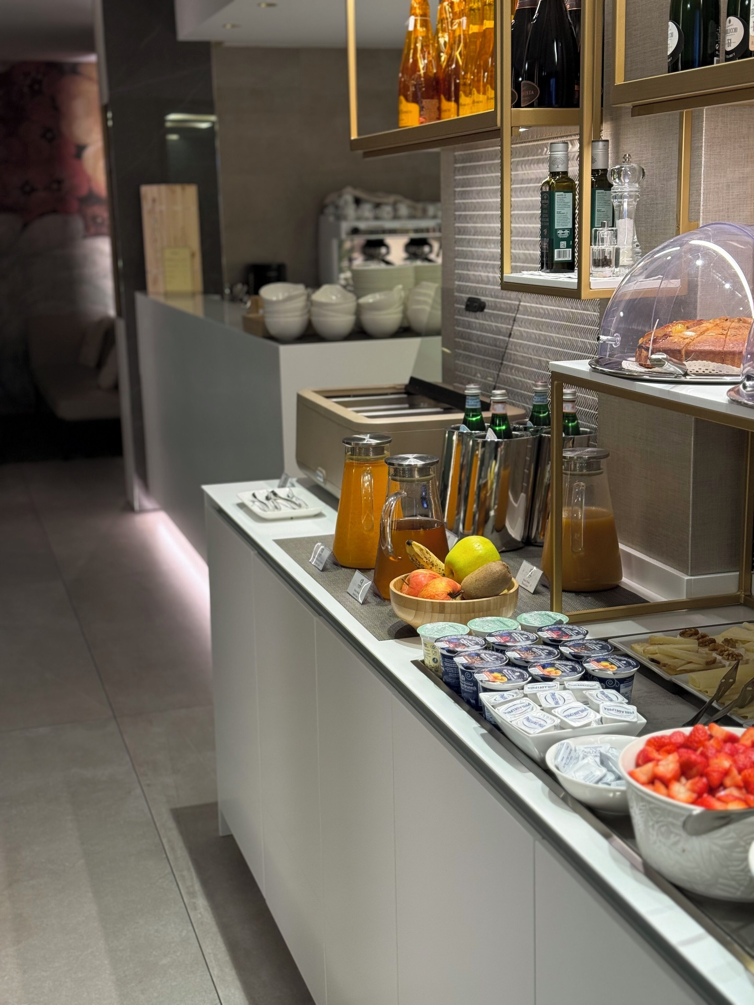 A breakfast buffet with various food items, including fruits, yogurt, and pastries.