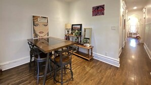 A dining area with a wooden table and chairs, a painting, and a mirror on the wall. - 2-bedroom large impeccable apartment in fabulous Montréal. (Montréal)