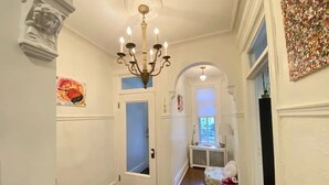 A hallway with white walls, a chandelier, a door with a frosted glass panel, and a radiator. - 2-bedroom large impeccable apartment in fabulous Montréal. (Montréal)