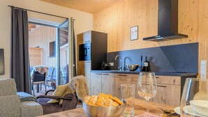 Una cocina moderna con paredes de madera, un microondas negro y un fregadero.