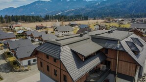 Zona residencial con casas modernas, una montaña destacada al fondo y cielo despejado.