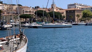 Uma marina com barcos atracados, cercada por edifícios e árvores.