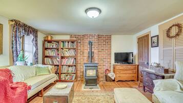 Ein gemütliches Wohnzimmer mit Kamin, Bücherregal, Sofa und Fernseher.