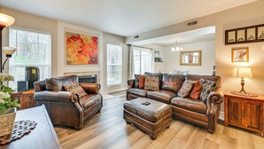 A spacious living room with leather sofas, a coffee table, and a fireplace. - Cozy Family Retreat! Home in Charlotte Suburbs (Charlotte)