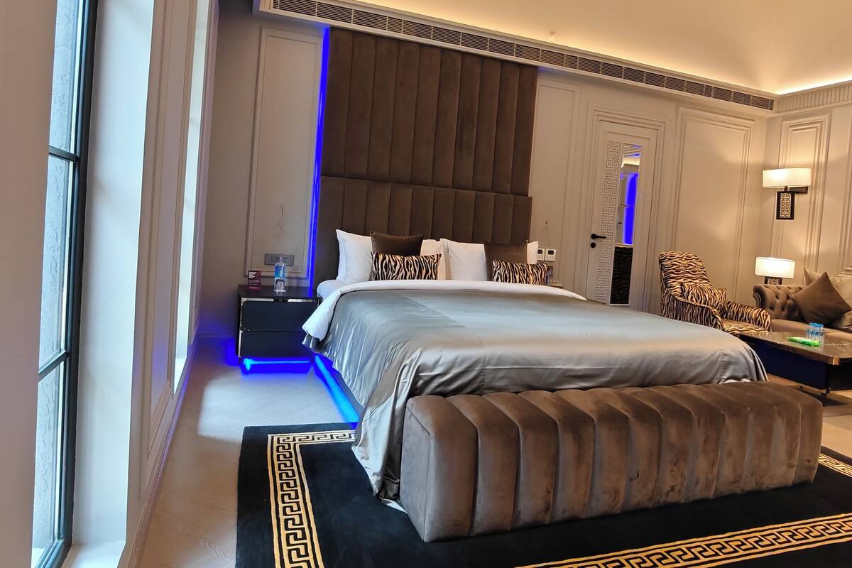 Ein modernes Schlafzimmer mit einem großen Bett, einem Nachttisch, einem Sessel und einem Schreibtisch.