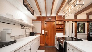 Una cucina moderna con piani di lavoro bianchi, mobili in legno e forno integrato.