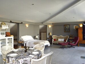 A spacious room with a bed, a dining table set for two, and a seating area with a chair and a sofa. - Winahost Loft Santa Cruz (Santa Cruz de Tenerife)