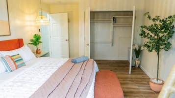 Une chambre à coucher avec un lit, une table de chevet et une plante en pot.