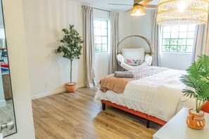 A bedroom with a bed, a hanging chair, a potted plant, and a window. - Agave Azul Villa | Monthly/Weekly Discounted Rates (Clinton)