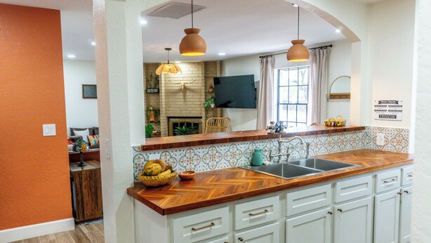 A kitchen with a wooden countertop, white cabinets, a built-in sink, and pendant lighting. - Spacious 3BR Home in Clinton. Weekly & Monthly Discounts Available! (Clinton)