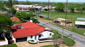 A residential area with a house featuring a red roof, a garage, and a well-maintained lawn. - Agave Azul Villa | Monthly/Weekly Discounted Rates (Clinton)