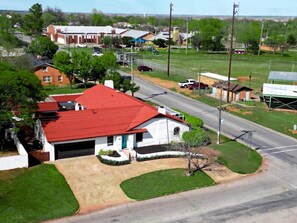 A residential area with a house featuring a red roof, a garage, and a well-maintained lawn. - Agave Azul Villa | Monthly/Weekly Discounted Rates (Clinton)