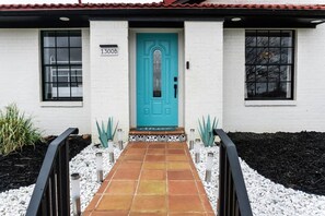 A building with a turquoise door, white walls, and a tiled walkway leading to the entrance. - Agave Azul Villa | Monthly/Weekly Discounted Rates (Clinton)