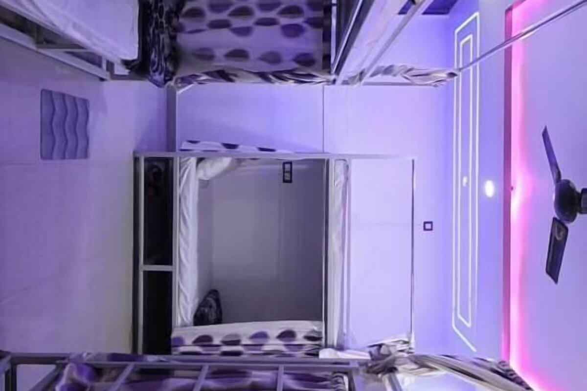 A room with a bunk bed, a mirror, and a ceiling with a unique pattern.