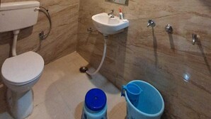 A bathroom with a toilet, sink, and shower. - Viraj Homestay (Varanasi)