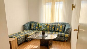 A room with a sectional sofa, a coffee table, and a door with a brass handle. - Cozy Convenient Room Prime Location (Vienna)