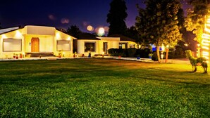 A well-lit residential building with multiple entry points and a spacious front lawn. - Shakti Resort (Behror)
