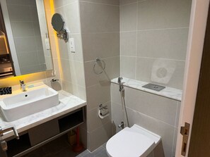 A modern bathroom with a sink, mirror, and shower. - Studio with Canal View | Damac Maison Business Bay (Dubai)
