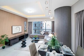 Ein modernes Wohnzimmer mit einer Couch, einem Esstisch und einem großen Fenster.