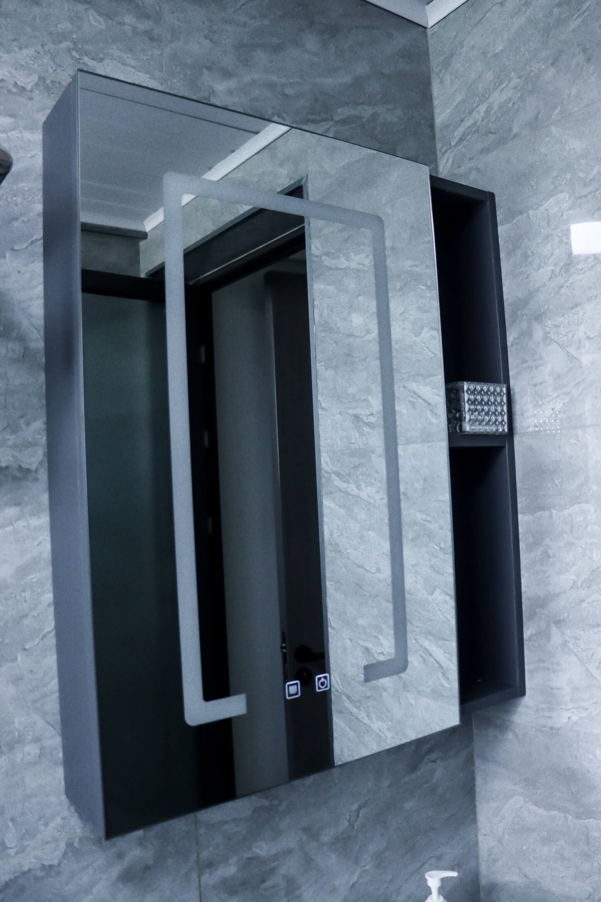 Un baño moderno con un espejo grande, lavamanos integrado y zona de ducha.