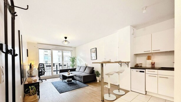 A modern apartment with a living room, kitchen, and balcony. - L'Ensoleillé Levallois – Apartment near metro (Levallois-Perret)