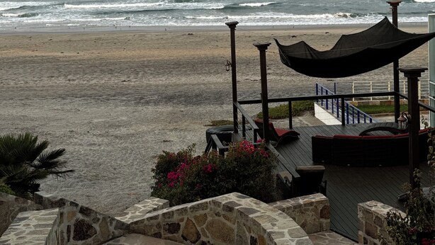 A beach view with a wooden deck and stone walls. - Tres Corazones Grand Suite for two (Playas la Misión)