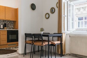 Eine moderne Küche mit Holzausstattung, einem schwarzen Backofen und einer Essecke mit Tisch und Stühlen.