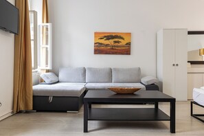 Ein modernes Wohnzimmer mit einer Couch, einem Couchtisch und einem Baumgemälde an der Wand.