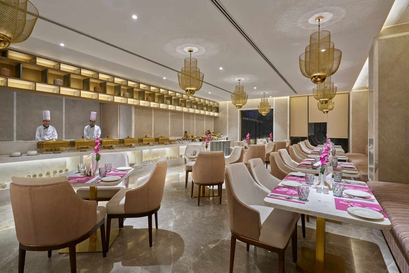 Un restaurant moderne doté de longues tables conviviales, de hauts plafonds et d’éléments d’éclairage décoratifs.
