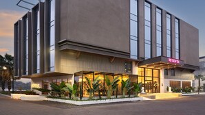 Un hôtel moderne doté d’un toit plat, de grandes fenêtres et d’une entrée bien éclairée.