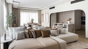 A modern living room with a sectional sofa, a dining area, and a kitchen. - Ultimate Luxury Penthouse w Pool Marina Views (Dubai)