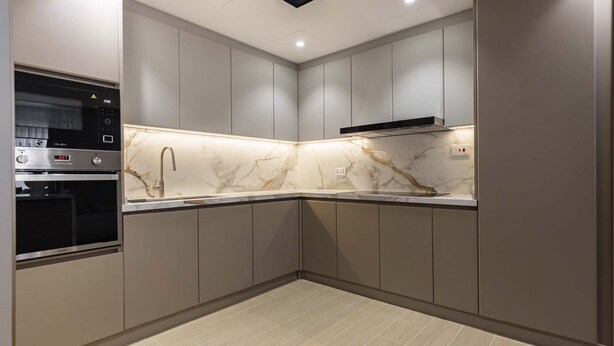 Eine moderne Küche mit integrierten Geräten, einer Marmor-Spritzschutzleiste und einem eleganten Design.