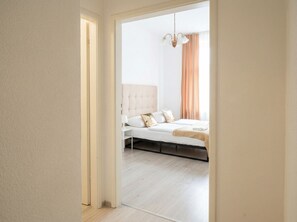 Ein Schlafzimmer mit Bett, Nachttisch und einer Pendelleuchte.