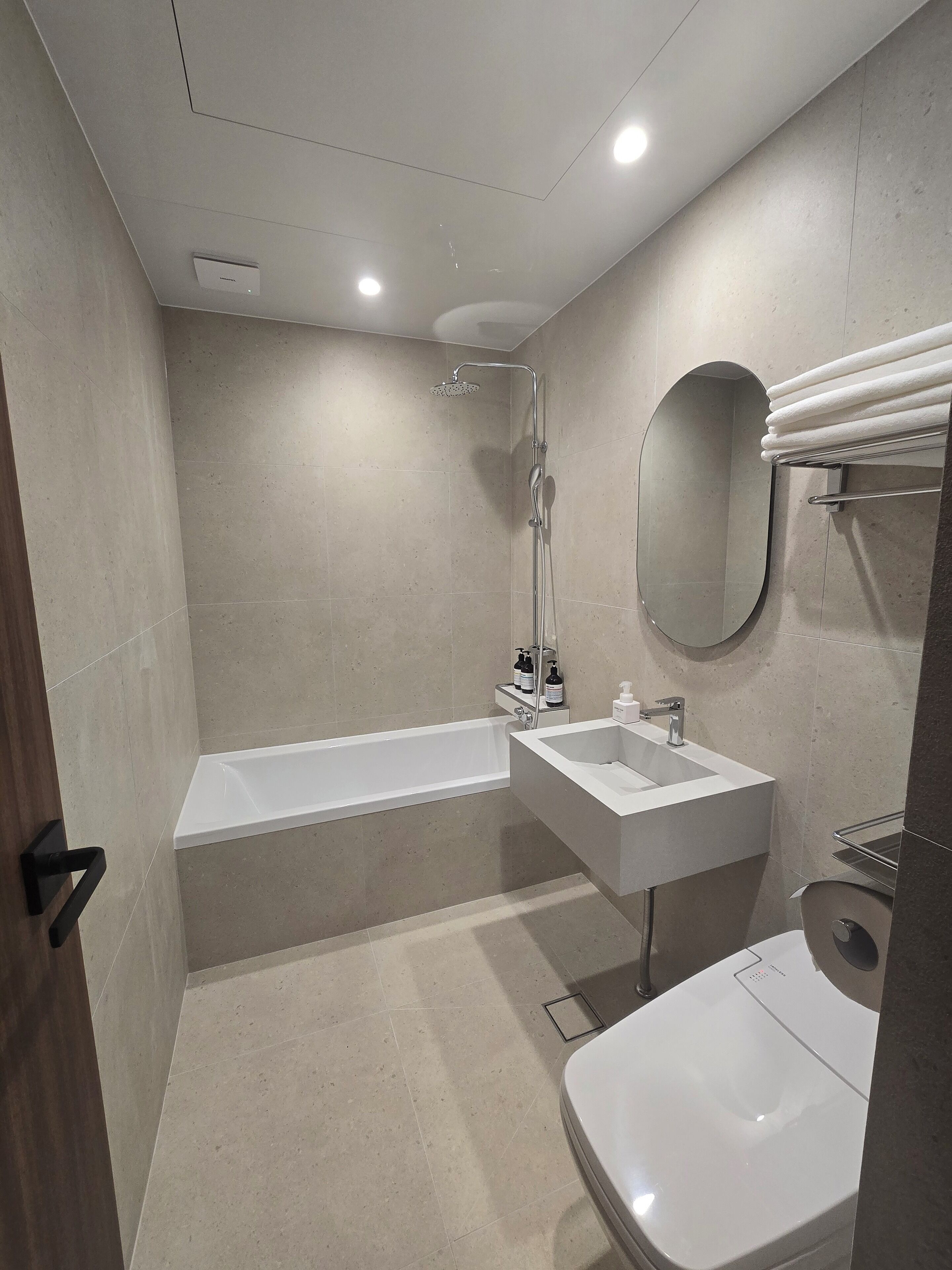 A modern bathroom with a bathtub, a sink, and a toilet.