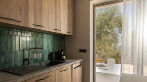 A modern kitchen with wooden cabinets, a green tiled backsplash, and a built-in dishwasher. - Cossoro Cave Villa Vasilikos (Vasilikos)